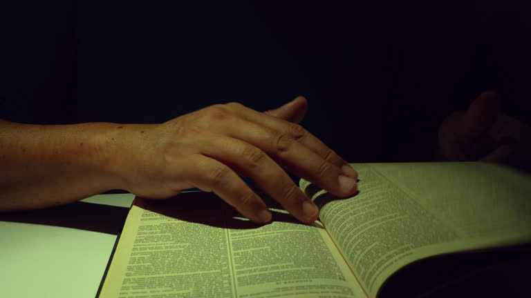 Christian reads holy bible in the dark room