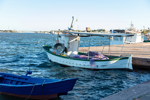 small fishing boats moored on the waterfront in the city Sant'Antioco, Sardinia, Italy