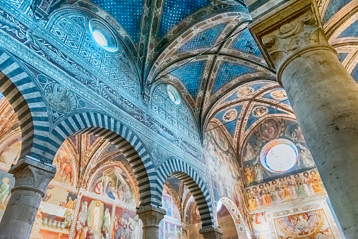 SAN GIMIGNANO, ITALY - JUNE 21: Interior of the Collegiate Church of Santa Maria Assunta, iconic basilica and major landmark in the historic centre of San Gimignano, Italy, June 21, 2019