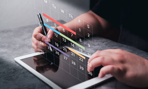 istock Woman use digital tablet to mark dates on virtual hologram calendar. 2149953856