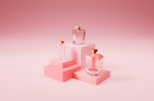 Glass bottle of fragrant eau de toilette against a background of pink peonies. Female perfume concept. Mock up. Close up photo
