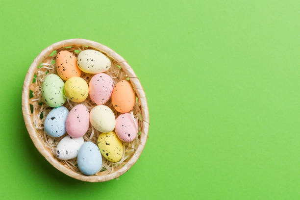 istock Colorful Easter eggs in wicker basket against colored background, closeup. top view with copy space 2149956685