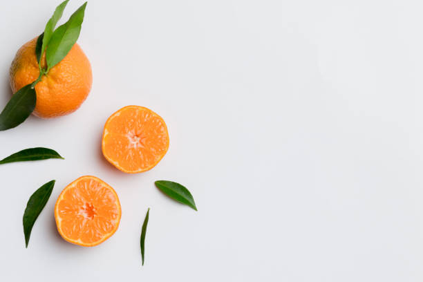 istock Many fresh ripe mandarin with green leaves on colored background, top view, space for text 2149956696