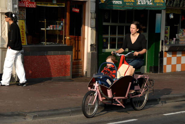 Holland, Netherlands - August 24, 2007: Mother with baby on bicycle in Amsterdam