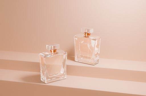 A stylish bottle of perfume stands on a white podium in the form of an arch and small pink roses. The modern image of perfume, fragrance