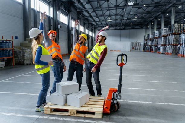 istock Confident team, managers, engineers wearing hard hats, work wear and vests working in warehouse 2149960673
