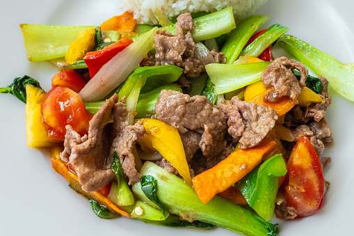 Stir frying beef with sweet peppers and bok choy. Spicy beef with vegetables. Asian style food. Top view. Colorful stir-fry closeup