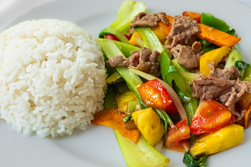 Stir frying beef with sweet peppers and bok choy and rice. Spicy beef with vegetables. Asian style food. Top view. Colorful stir-fry closeup