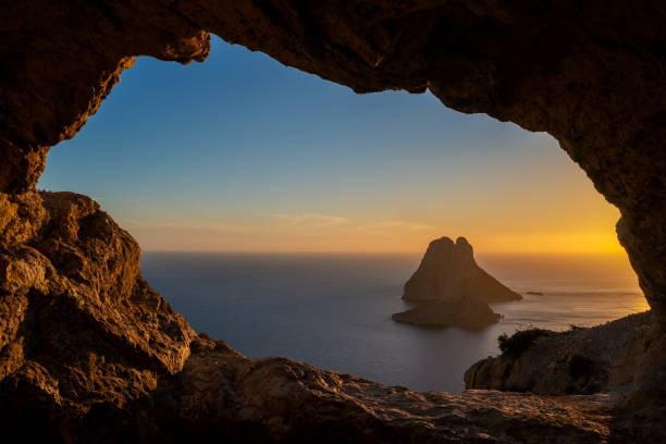istock Es Vedra islet view through a rock hole at sunset 2149963024