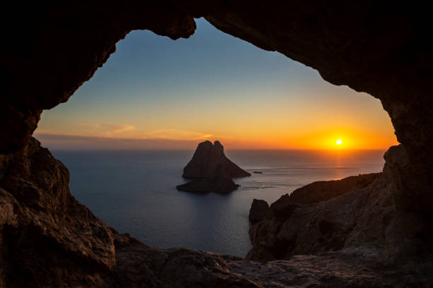 istock Es Vedra islet view through a rock hole at sunset 2149963443