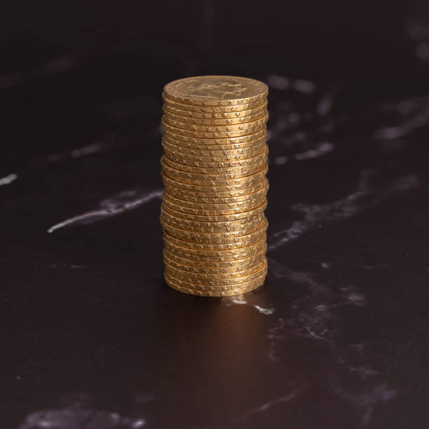 istock Paris, France - 03 26 2024: Still life. Close-up view stack of golden Louis coins on a black and white marble surface 2149967438