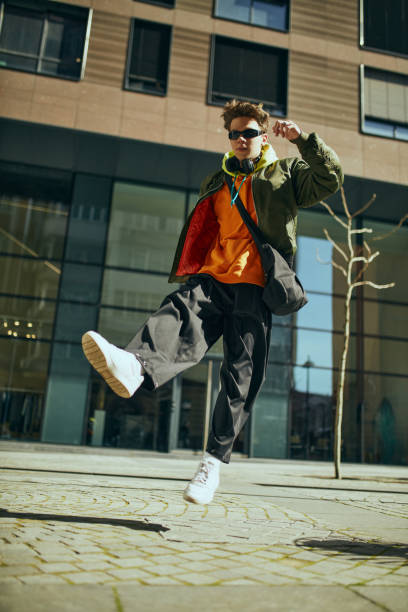 istock Trendy dressed young guy, student in oversized neon clothes posing vibrant portrayal of contemporary streetwear. 2149967755