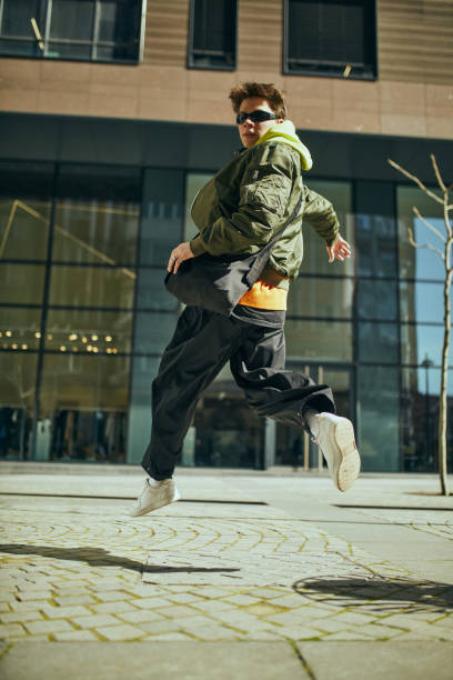 istock Stylish student, dressed oversized neon outfit merging urban chic with youthful exuberance against cityscapes. 2149967757