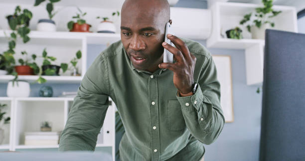 istock Internet, black man and talking with phone call in office for project updates or communication and feedback. Interior designer, mobile and conversation for discussion or task development and serious. 2149968416