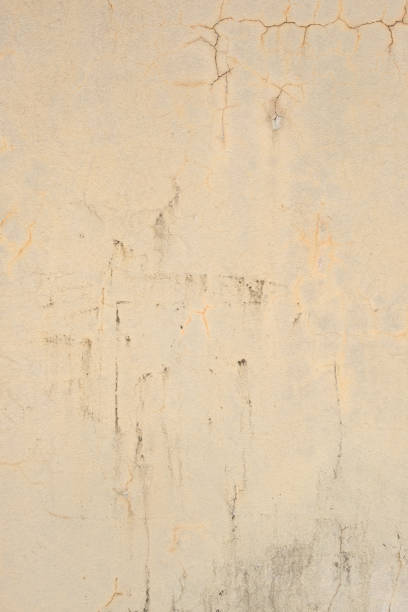 Close-up on an old damaged beige wall.
