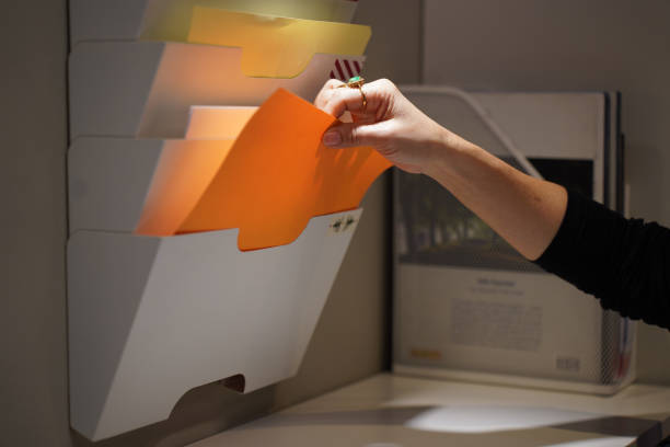 istock Woman insert paper into folder on the wall in office 2149971313