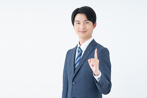Asian business man celebrating with arms in the air, isolated on white background.