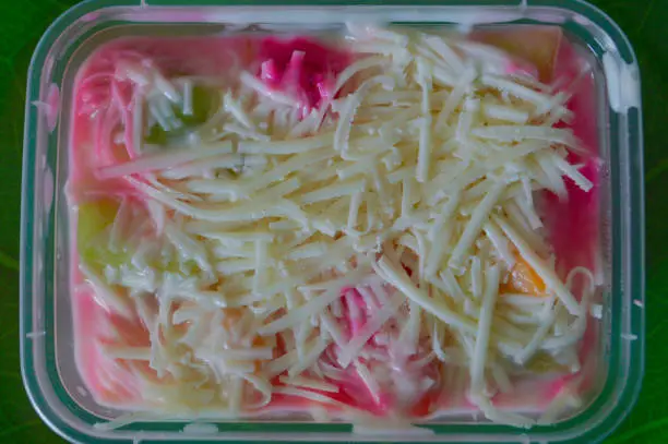 Close-Up Top-Down View Of Homemade Creamy And Fresh Fruit Salad With Mayonnaise And Milk Cheese In A Plastic Container
