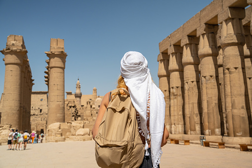 Woman walking in to Temple Colonnade of Amenhotep III from the Courtyard of Ramses II at Luxor Temple, in Luxor, Thebes, Egypt.