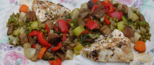 istock Slices of cod cooked with aromatic plants served with various vegetables in portions 2149977916