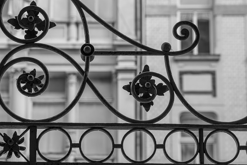 a decorative nostalgic metal fence in the city in black and white
