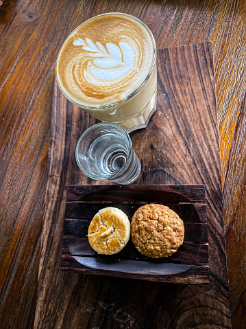 Coffee latte and biscuit at table