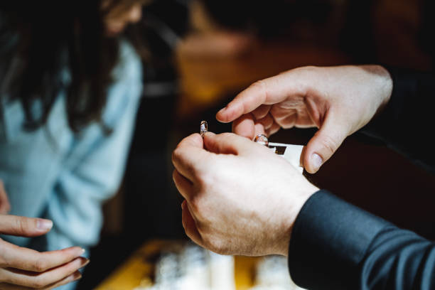 istock Mans hand gently places a ring on womans finger during the sharing event 2149981227