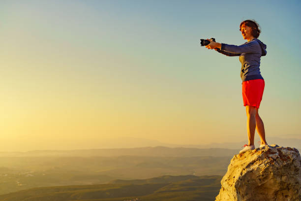 Tourist woman with camera taking travel photo from coastal spanish landscape, Mesa Roldan location in province Almeria, Andalusia Spain. Cabo de Gata Natural Park.
