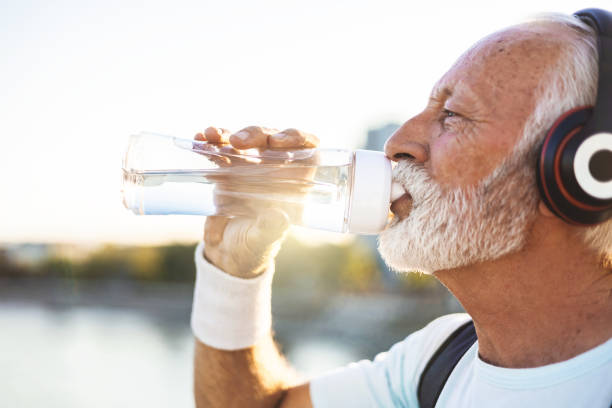 istock Active senior bearded man taking break after hard exercise on the bridge during sunset. Healthy retirement lifestyle. Sports fitness and physical exercises for the elderly. 2149986160