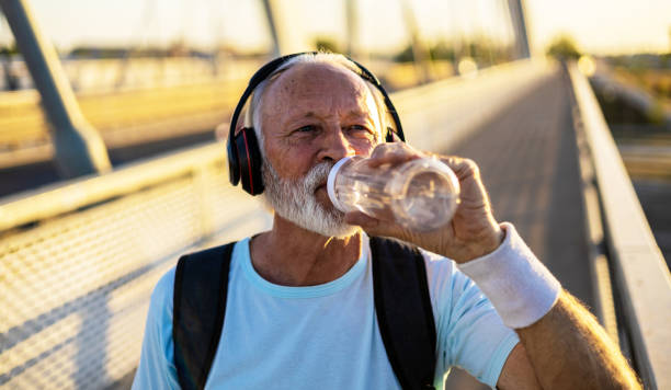 istock Senior man drinking water from reusable water bottle. Senior man taking a break and drinking water after practice. 2149986222
