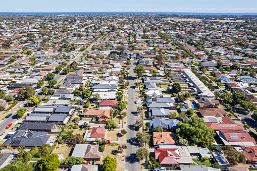 Aerial view Adelaide sprawling single-level suburb looking west towards coast: residential suburbs of Woodlands Park/Edwardstown/Morphettville, Glenelg South with gulf waters on the horizon. Morphettville Racecourse is visible in top right of frame.