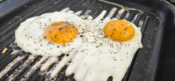 istock Eggs cooked with rosemary spice on a square  grill pan 2149990173