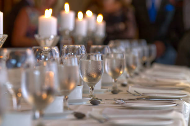 Glasses of water in a line at wedding reception table Bokeh focus of a glass of water at a place setting on a table for a wedding reception. beautiful table setting stock pictures, royalty-free photos & images