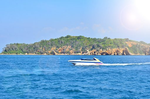 The speedboat sailing in the deep blue sea combined with the beautiful view of the sky.