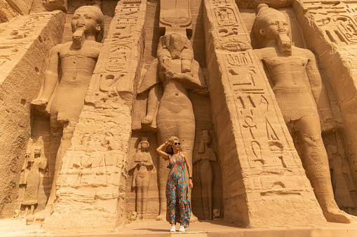 Woman standing in front of the temple of Hathor and Nefertari, dedicated to the goddess Hathor and Ramesses II's queen, Nefertari, at Abu Simbel, Egypt