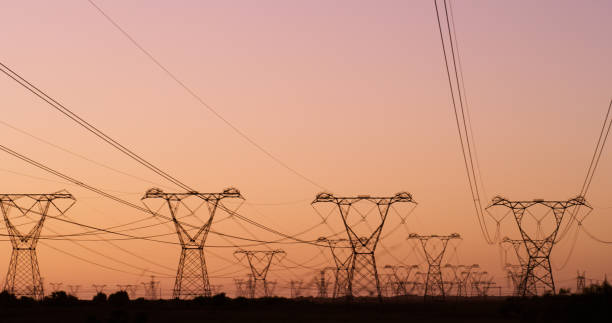 istock Power line, sunset and infrastructure for electricity, transmission and grid for voltage distribution. Pylon, towers and transformer at dusk in rural area, engineering and substation with cable 2149992714