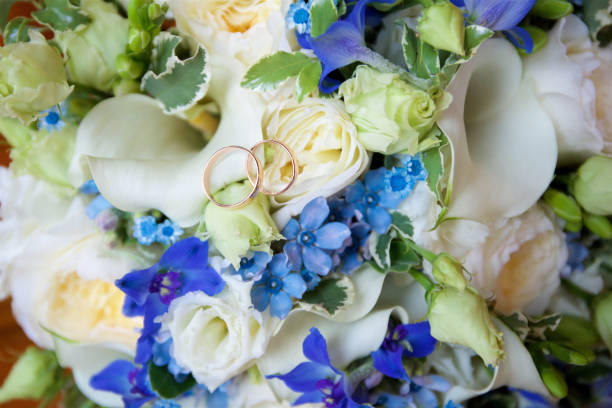 istock Wedding rings lie on flower petals 2149995108