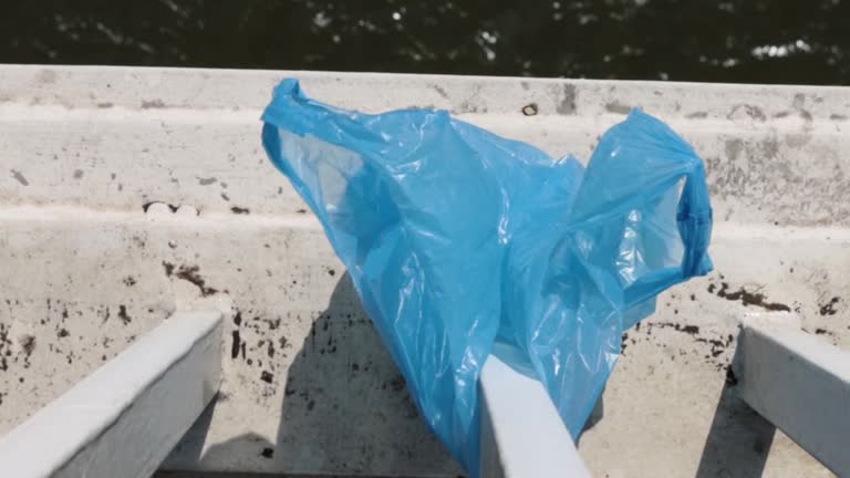 Blue Plastic bag hanging on the railing of Elisabeth bridge over Donau river in Budapest. Garbage in the city. Environmental pollution concept. Ecological disaster, catastrophe. Selective focus