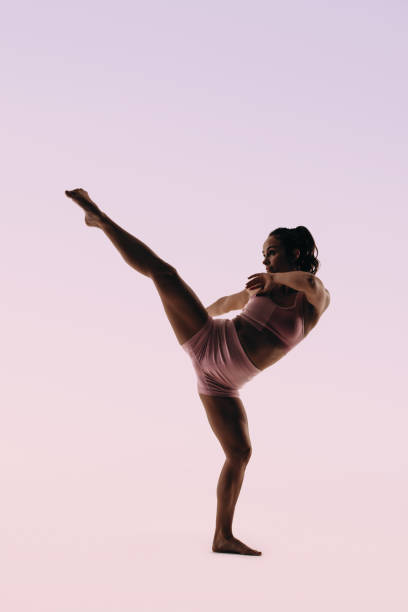 istock Skilled female gymnast practicing her routine with an acrobatic kick 2149998064