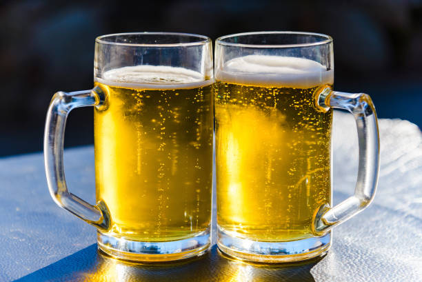 istock Two glasses of light beer on a table sunset outdoors.Summertime.Closeup. 2149998291