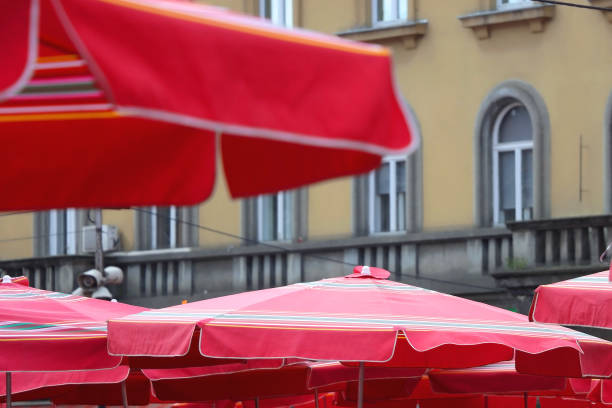 The Saint-Emilion region in France on October 01, 2023: People gathering under shade umbrellas of an outdoor cafe Restaurant in the rustic wine producing town of Saint-Emilion, France