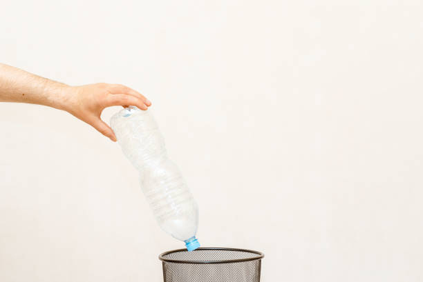 istock The plastic bottle is thrown into the trash basket for disposal and recycling.White,gray background,selective focus,copy space. 2149998947