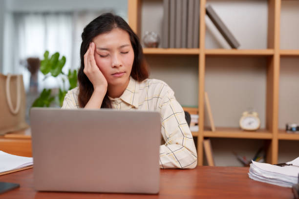 istock Office worker taking a momentary break from laptop work, eyes shut, hand on forehead, relaxing. Moment of reprieve for diligent worker, closing eyes for rest, hand on head, amidst work tasks. 2149999282