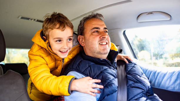 istock Caucasian boy embracing father from behind, while his father driving an car 2150000102