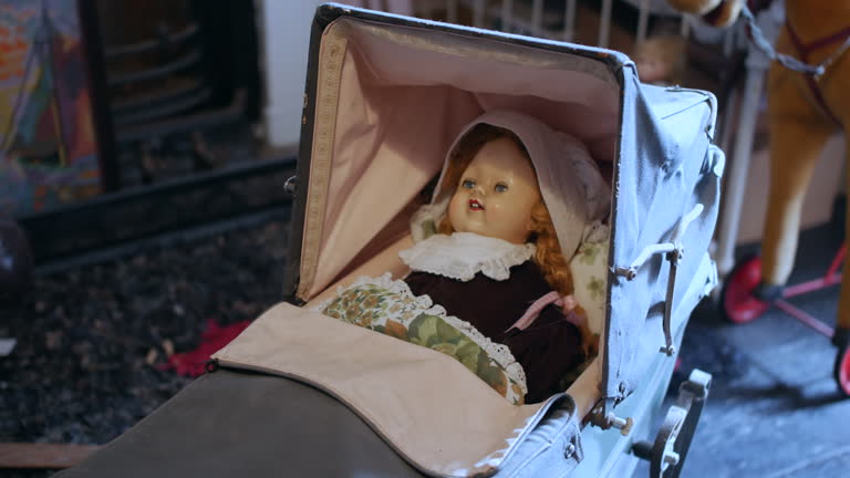 Close-up of an antique doll in a vintage pram, perfect for themes of nostalgia, childhood, and historical reenactment. Retro toy in a detailed setting for period-piece productions or decoration