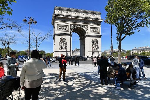 Paris, France-04 23 2024: Tourists taking photos in front of the Arc de Triomphe in Paris, France.