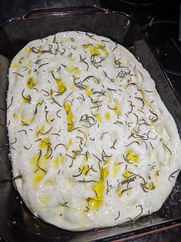Raw Focaccia dough in a dish ready to bake
