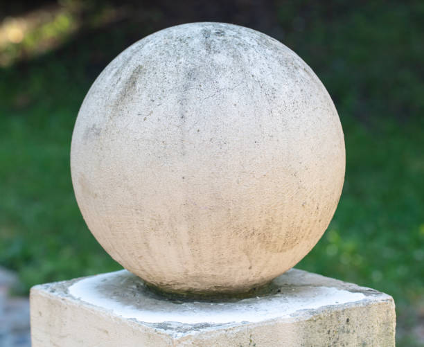 White concrete ball on the fence.