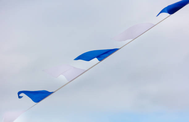 istock Festive blue white flags against the sky with clouds 2150004579