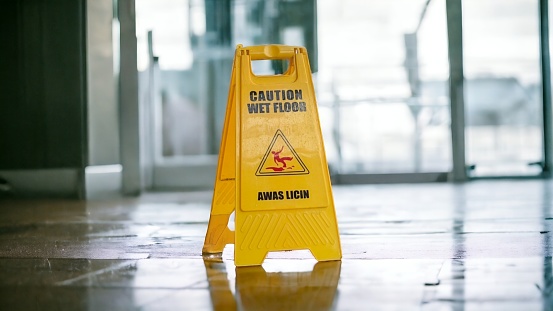 A slippery floor warning sign is placed on the floor that has just been mopped